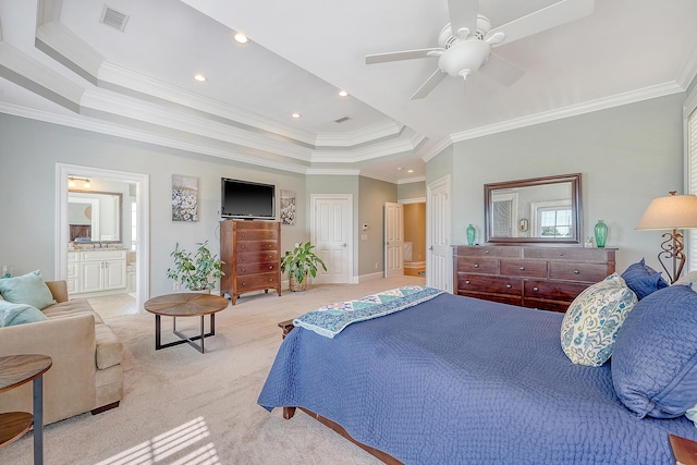 bedroom with light carpet, a tray ceiling, visible vents, crown molding, and ensuite bath