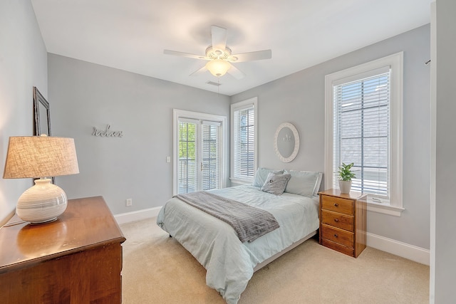 bedroom with visible vents, a ceiling fan, baseboards, and light carpet