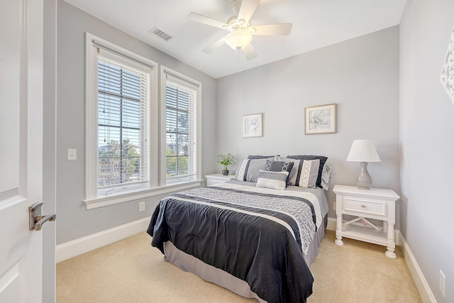 carpeted bedroom with ceiling fan, baseboards, and visible vents