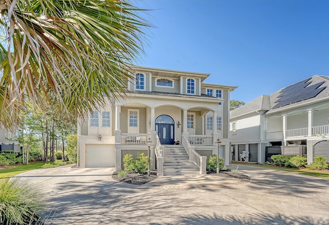 view of front of property featuring stairway, an attached garage, driveway, and covered porch