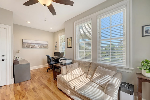 office area with plenty of natural light, ceiling fan, baseboards, and light wood-style flooring
