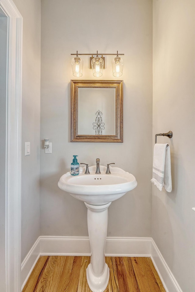 bathroom with baseboards and wood finished floors