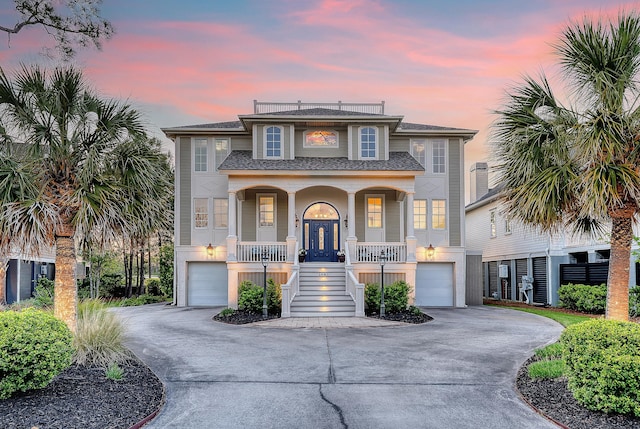 view of front of property with an attached garage, driveway, and stairs