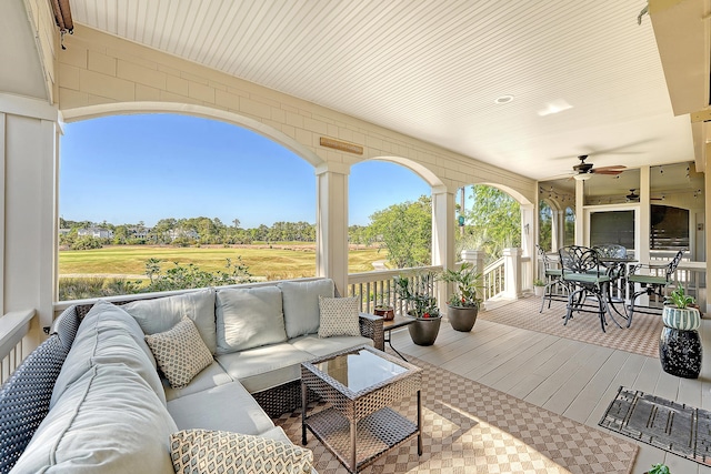 wooden deck with an outdoor hangout area, a ceiling fan, outdoor dining area, and golf course view