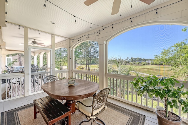sunroom / solarium with outdoor dining area and ceiling fan
