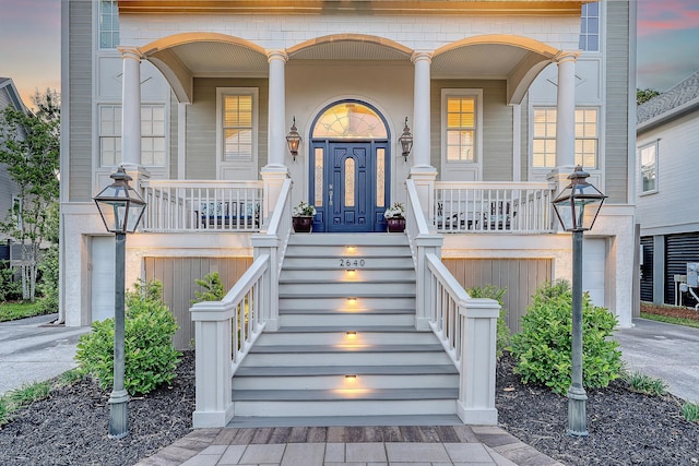 exterior entry at dusk with driveway and covered porch