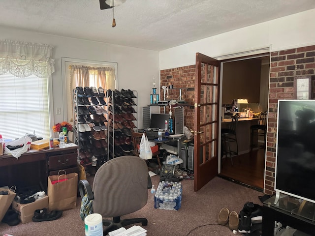 home office featuring a textured ceiling, carpet flooring, and ceiling fan