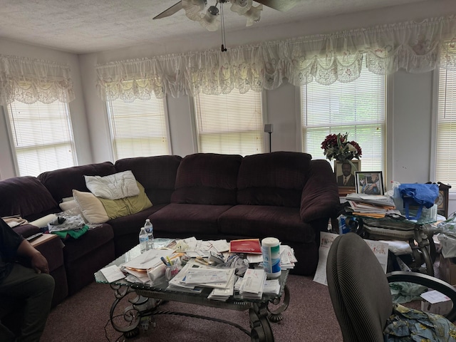 carpeted living room with a textured ceiling and ceiling fan