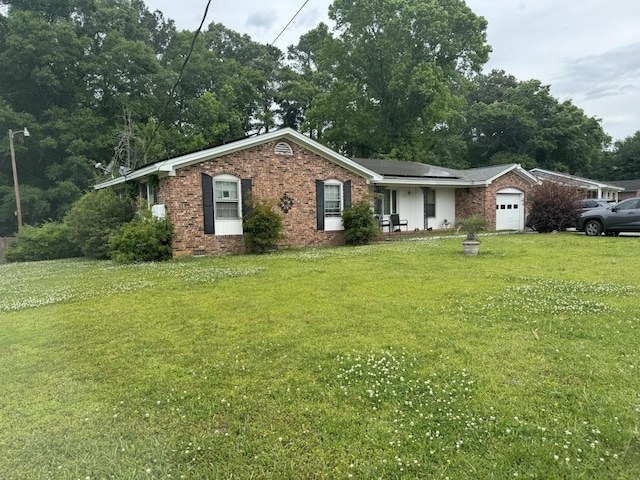 8520 Delhi Rd, North Charleston, SC 29406 - ranch-style home with a garage, a front yard, brick siding, and roof mounted solar panels