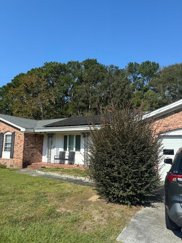 view of front facade with covered porch, a garage, and a front lawn