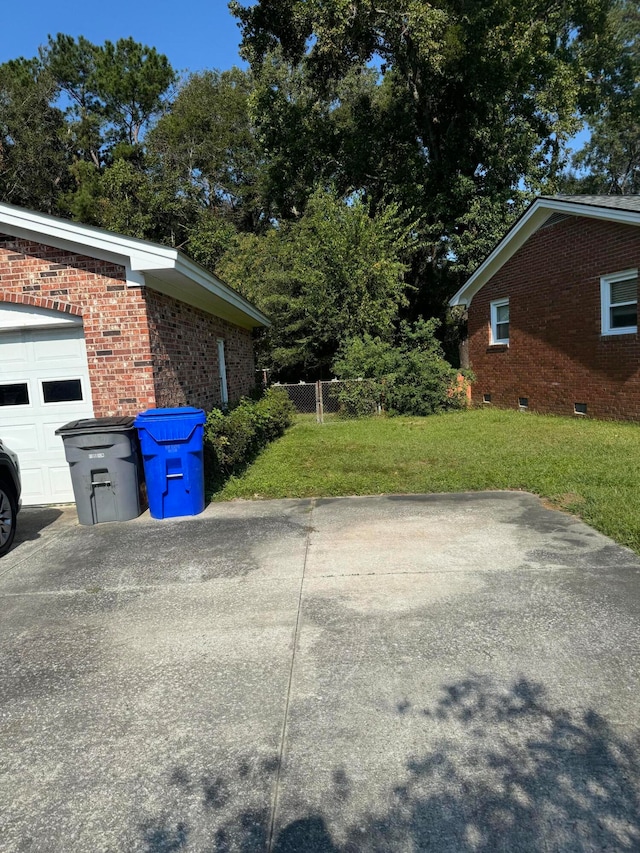 view of home's exterior with a garage and a lawn