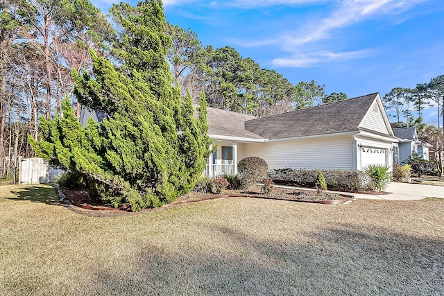 view of front of home featuring a garage, driveway, a front lawn, and fence