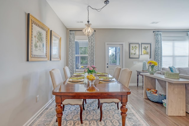 dining area with light wood-style flooring, a wealth of natural light, and baseboards