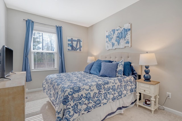 bedroom with baseboards and light colored carpet