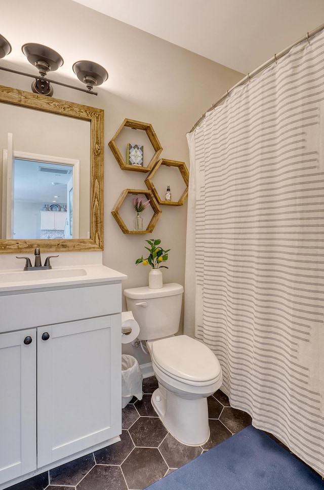 full bath featuring vanity, toilet, and tile patterned floors