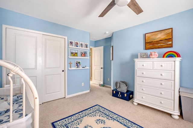 bedroom with a closet, light carpet, ceiling fan, and baseboards