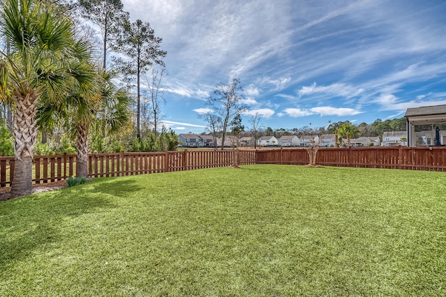 view of yard featuring a fenced backyard and a residential view