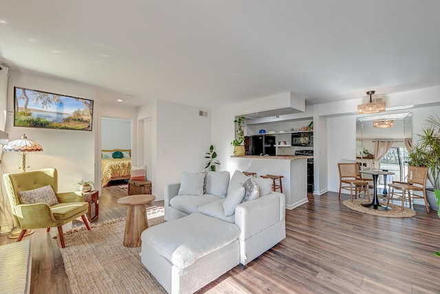 living room featuring wood finished floors, visible vents, and baseboards