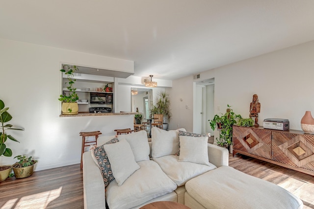 living area with visible vents, baseboards, and wood finished floors