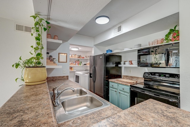 kitchen with washing machine and dryer, visible vents, a sink, and black appliances