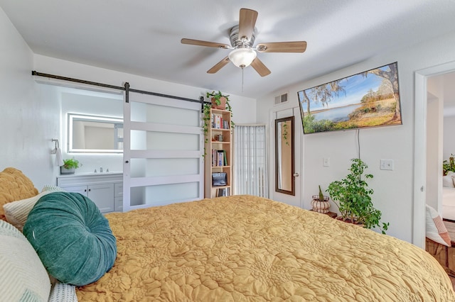 bedroom featuring a barn door, visible vents, and ceiling fan