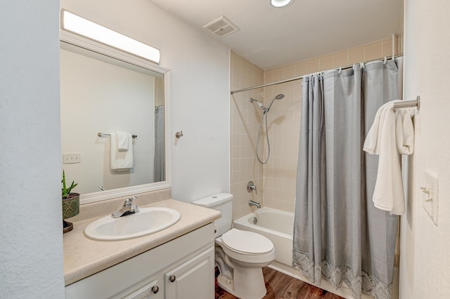 full bathroom with toilet, wood finished floors, vanity, visible vents, and shower / bath combo with shower curtain