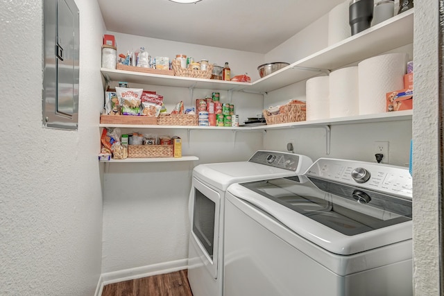 laundry room featuring a textured wall, washing machine and dryer, wood finished floors, laundry area, and baseboards