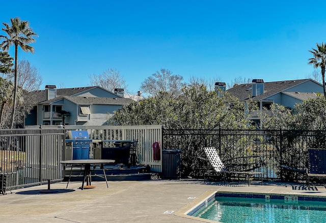 community pool with fence and grilling area