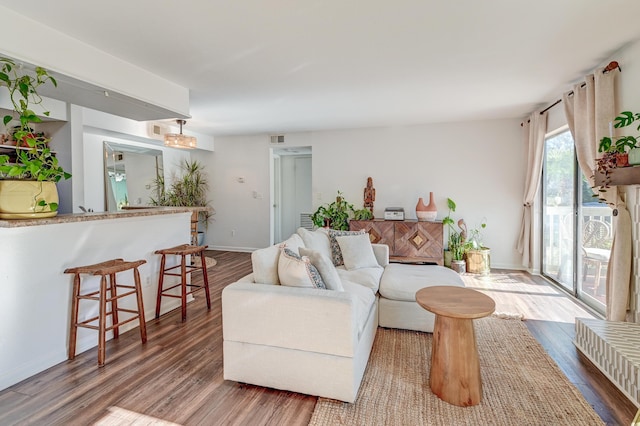 living room featuring visible vents, baseboards, and wood finished floors