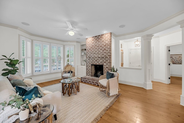 701 Hibbens Grant Blvd, Mount Pleasant, SC 29464 - living area featuring light wood-style floors, ornamental molding, ceiling fan, a brick fireplace, and decorative columns