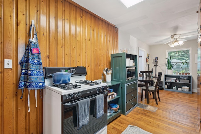 kitchen featuring ceiling fan, light hardwood / wood-style floors, and white gas stove