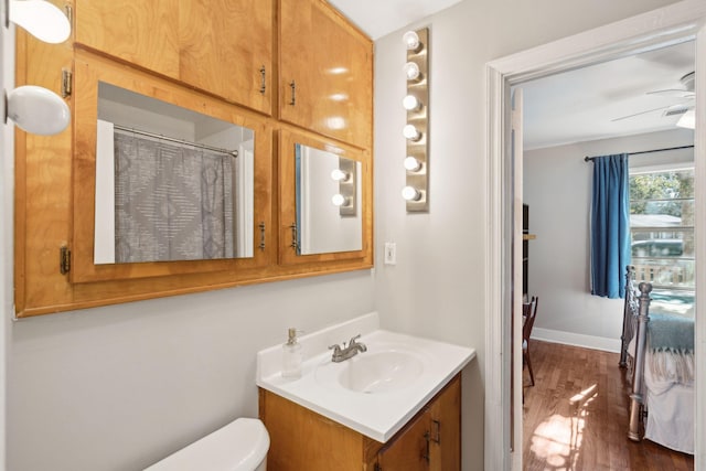 bathroom with toilet, ceiling fan, wood-type flooring, and vanity