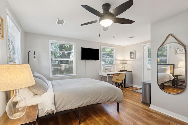 bedroom featuring light wood-type flooring, ceiling fan, and multiple windows