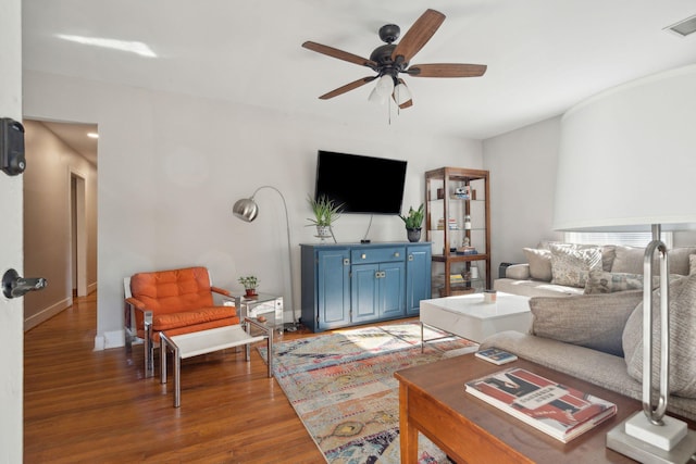 living room featuring ceiling fan and dark hardwood / wood-style flooring