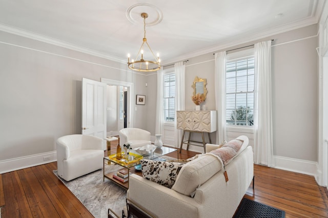 living room with ornamental molding, baseboards, a notable chandelier, and hardwood / wood-style floors