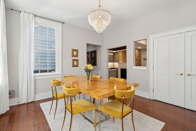 dining room featuring baseboards, a chandelier, and dark wood-style flooring