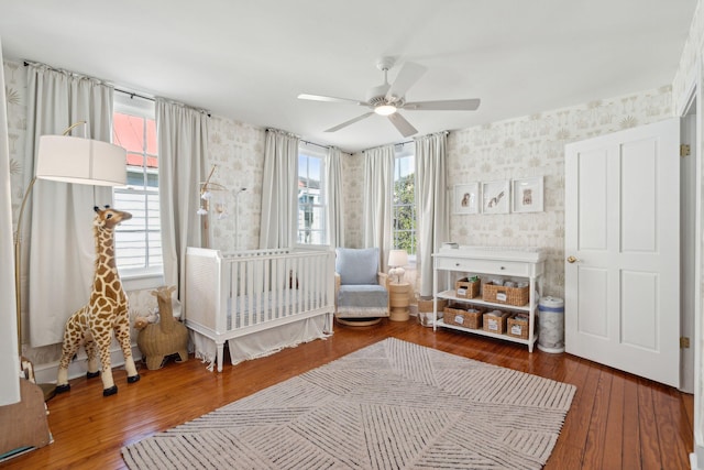 bedroom featuring wallpapered walls, ceiling fan, and hardwood / wood-style flooring