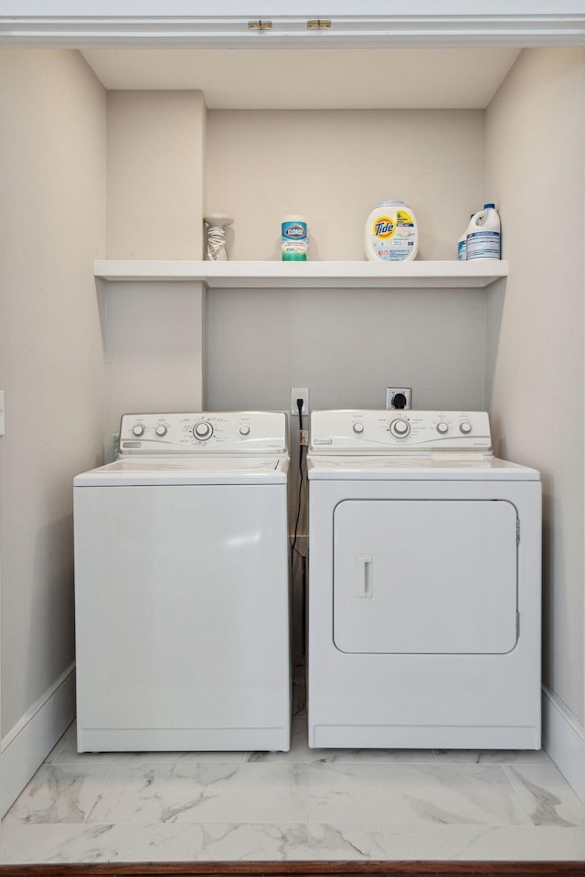 laundry area featuring baseboards, marble finish floor, laundry area, and washer and dryer