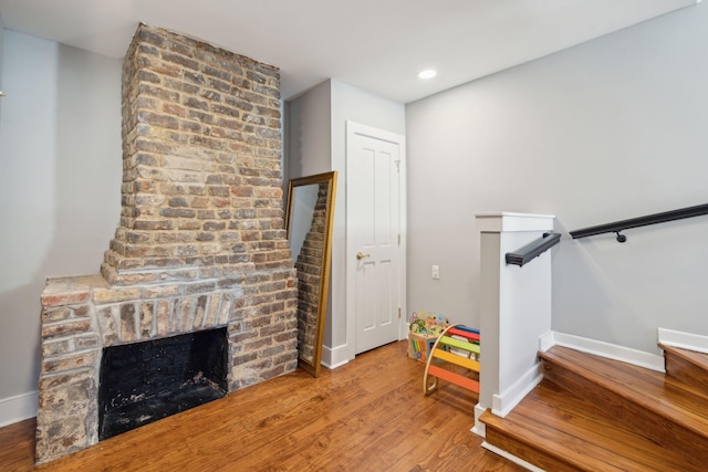 interior space with recessed lighting, a fireplace, wood finished floors, and baseboards