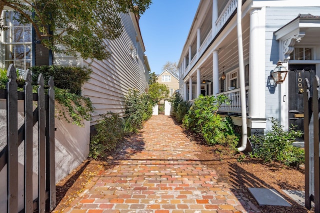 view of property exterior featuring covered porch and fence