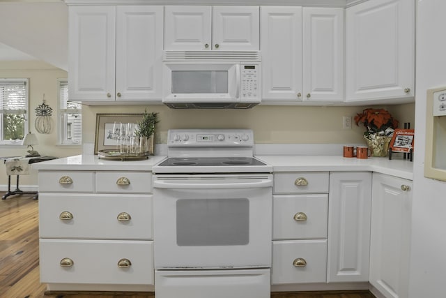 kitchen featuring hardwood / wood-style flooring, white cabinetry, and white appliances