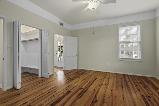 unfurnished bedroom with dark hardwood / wood-style flooring, a closet, and ceiling fan