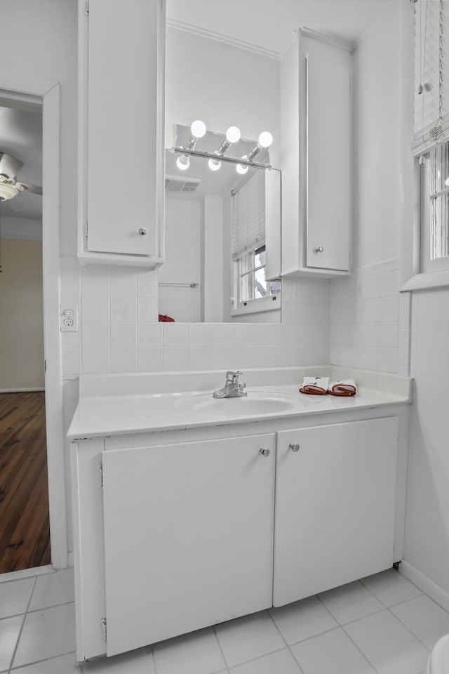 bathroom with tile patterned floors, backsplash, vanity, and a healthy amount of sunlight