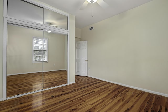 unfurnished bedroom featuring dark hardwood / wood-style floors, a closet, and ceiling fan