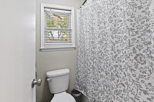 full bath featuring toilet and a shower with shower curtain