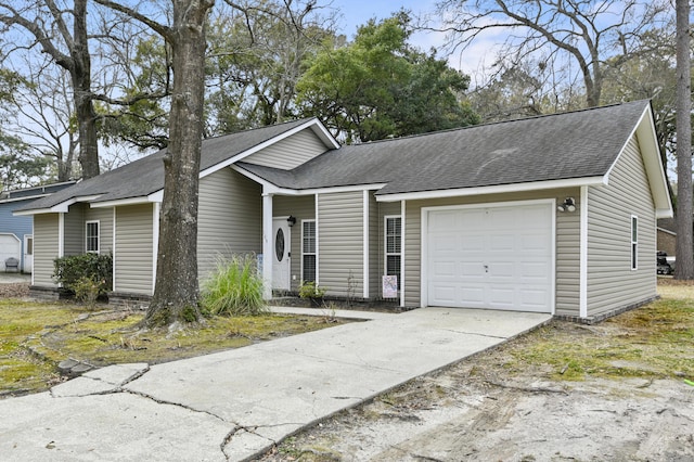 view of front of house with an attached garage, a shingled roof, and driveway