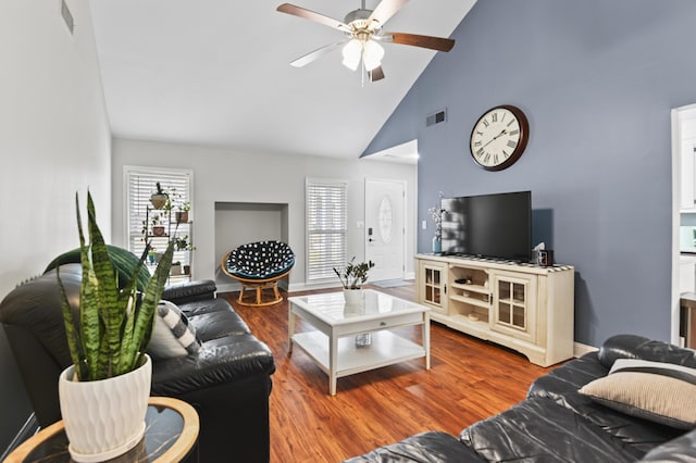 living room featuring wood finished floors, a ceiling fan, visible vents, high vaulted ceiling, and baseboards