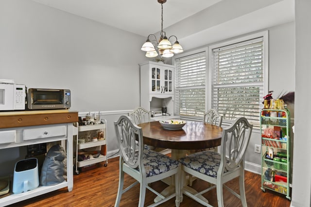 dining area with baseboards, a notable chandelier, and wood finished floors