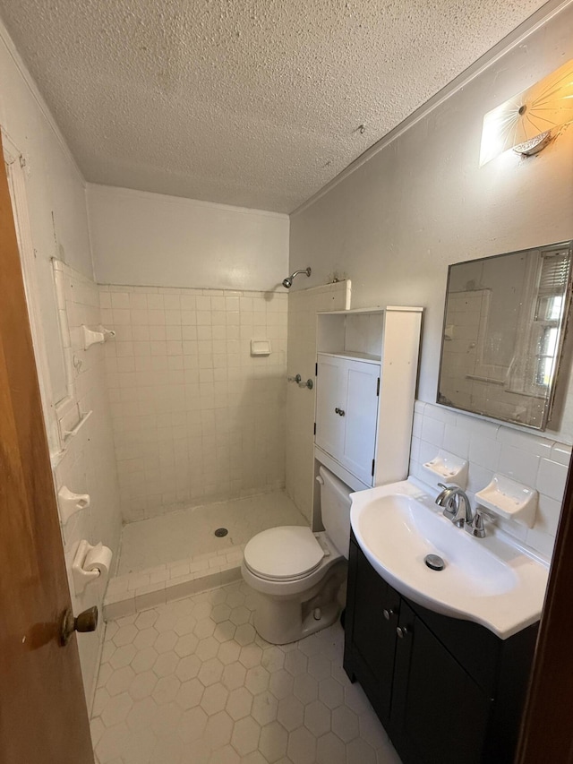 full bathroom with vanity, toilet, a textured ceiling, tile patterned floors, and a shower stall