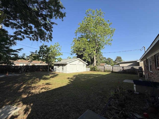 view of yard featuring an outbuilding, a fenced backyard, and a garage